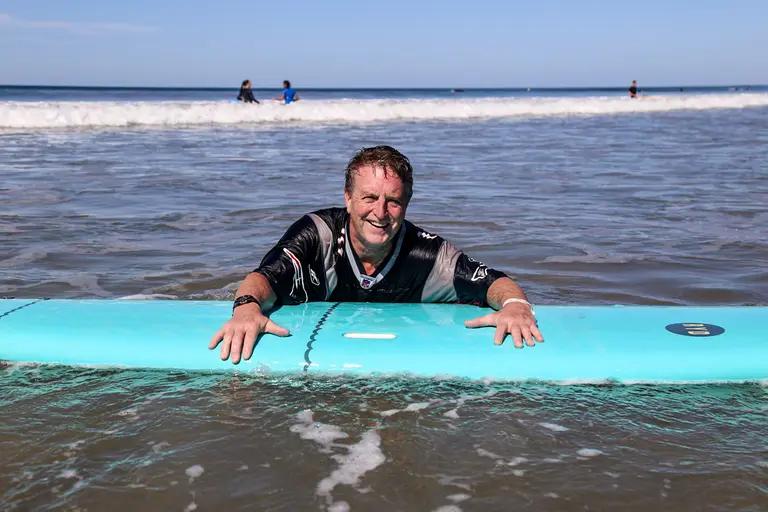 Group surf lesson high five moment on Santa Teresa beach Costa Rica